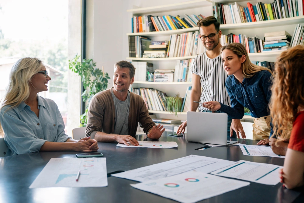 Group of happy business people working together on project in office.