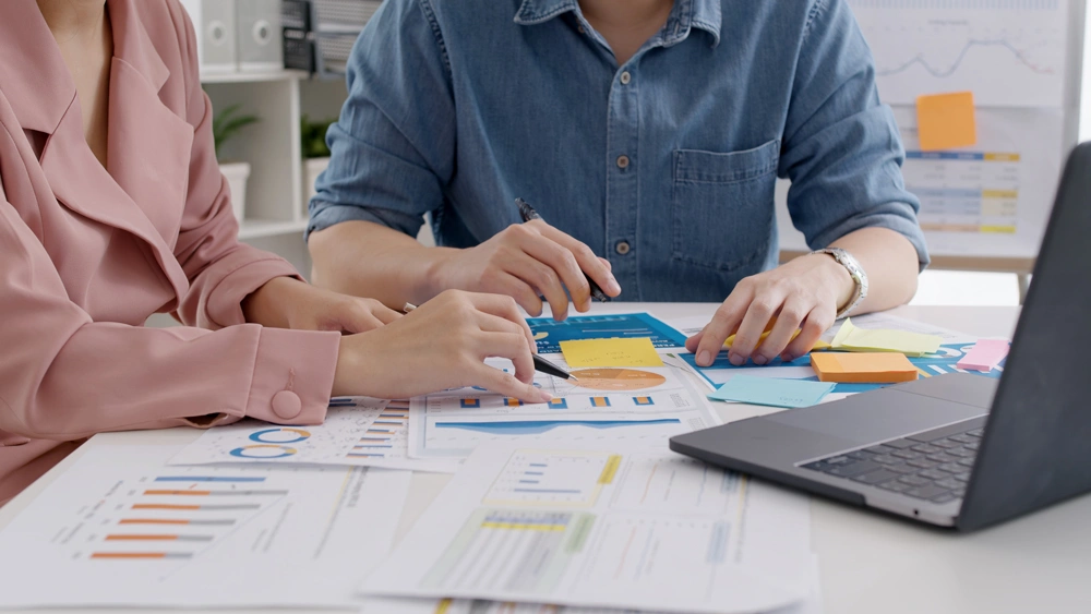 Two people looking at charts and graphs